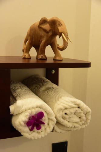 a statue of an elephant on a shelf with towels at The Kingfisher Hikkaduwa in Hikkaduwa