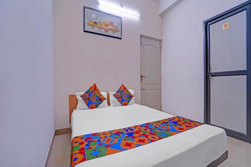 Un dormitorio con una cama con una manta colorida. en Via Lishikaas Inn, en Tākalghāt