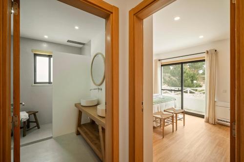 a bathroom with a sink and a mirror in a room at Carvalhal Beach House in Carvalhal