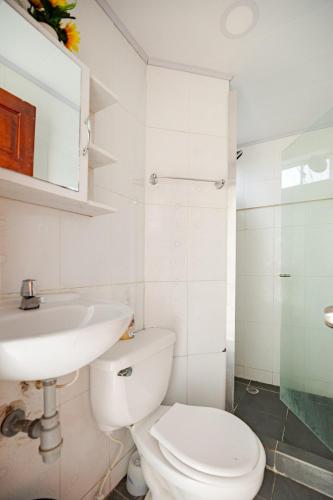a white bathroom with a toilet and a sink at cabaña villa luz in Santa Verónica