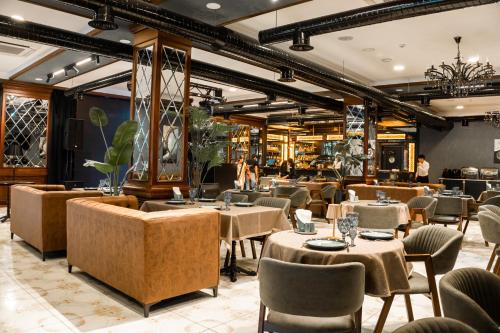 a restaurant with tables and chairs and people in the background at Alis Business Hotel baku in Baku