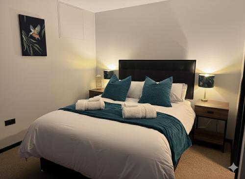 a bedroom with a large bed with blue pillows at The Wheatsheaf in Tempsford