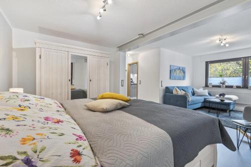 a bedroom with a bed and a living room at Ferienwohnung an der Volme in Meinerzhagen