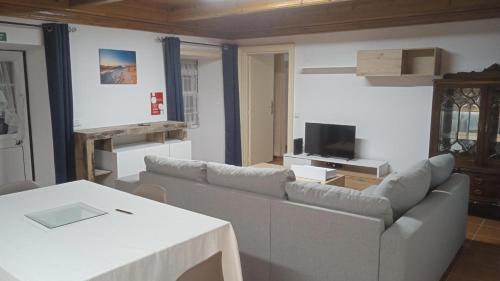 een woonkamer met een bank en een tafel bij Casa do Avô Almeida in Fajazinha