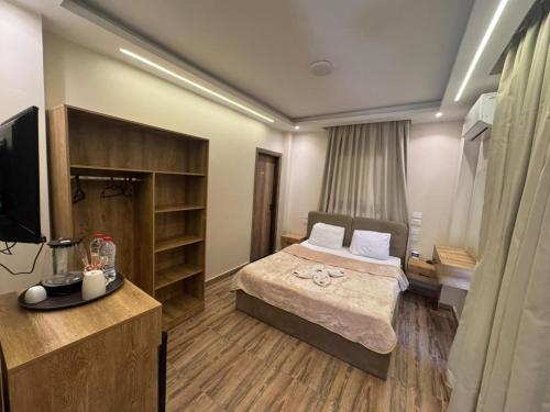 una habitación de hotel con una cama y un televisor en ArQa pyramids Hotel, en El Cairo