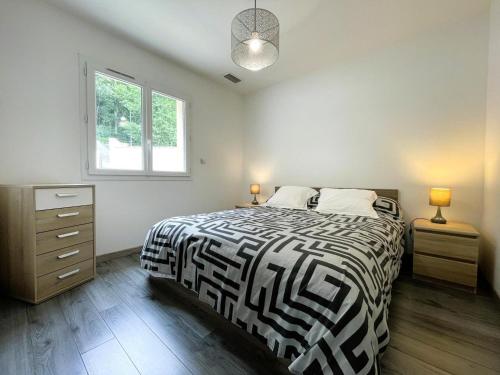 a bedroom with a black and white bed and a window at Gite l'oree du bois in Livron