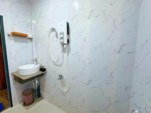y baño con ducha y paredes de mármol blanco. en Khu Camping & Homestay Ven Biển, en Ấp Phước Tĩnh