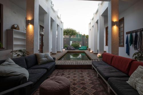 a living room with couches and a pool in a house at Axminster House in Muizenberg