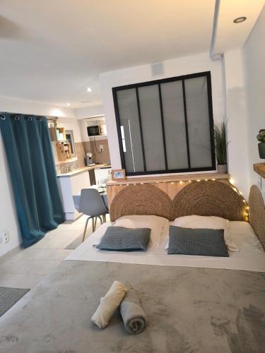 une chambre avec un grand lit et une grande fenêtre dans l'établissement agréable studio, à Narbonne