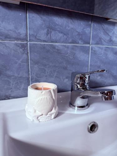 a candle and a cup on a bathroom sink at Vila Cristina in Mamaia Sat/Năvodari