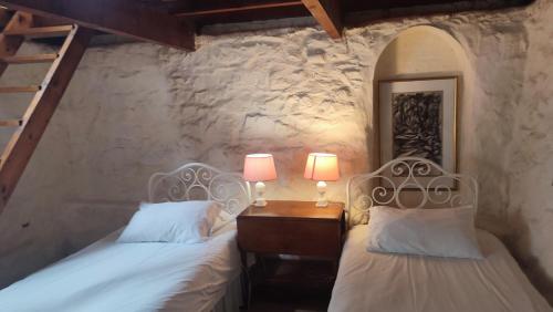 een slaapkamer met twee bedden en een tafel met twee lampen bij Stonehurst Guest House in Kaapstad
