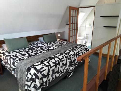 a bedroom with a bed with a black and white comforter at Suites on 74 in Worcester