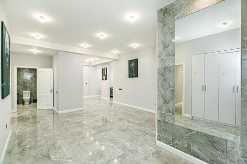 a large mirror in the middle of a room with a marble floor at Lux Apartment View Baku Formula 1 Street in Baku