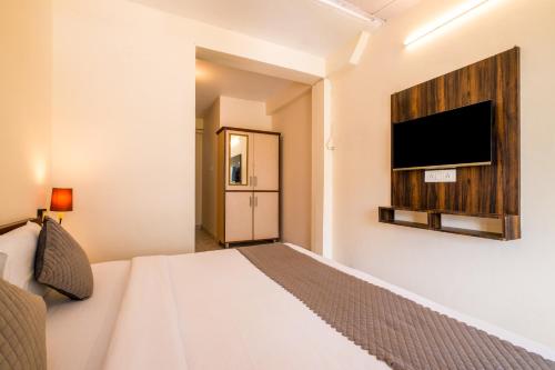 a bedroom with a bed and a flat screen tv at Artllers at Vicctoria House, All Mountain View rooms with Free Parking in McLeod Ganj