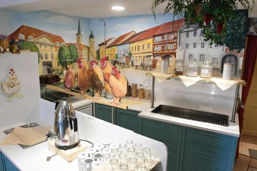 a kitchen with a mural of chickens on the wall at Hotel garni Goldene Henne in Arnstadt