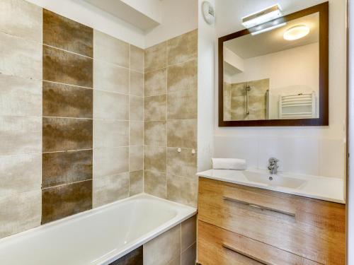 a bathroom with a tub and a sink and a mirror at Vacancéole - Les Demeures Torrellanes - Saint-Cyprien in Saint-Cyprien