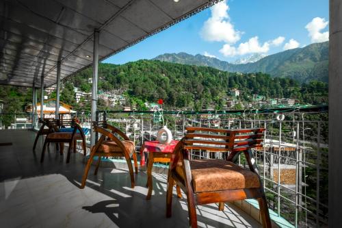 a balcony with chairs and a table with a view at Artllers at Vicctoria House, All Mountain View rooms with Free Parking in McLeod Ganj