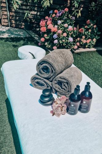 a table with towels and two bottles of soap and flowers at Sjiek Basiliek in Oudenbosch