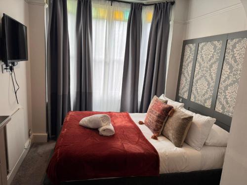 ein Schlafzimmer mit einem Bett mit einer roten Decke in der Unterkunft Regency Guest House in Cambridge