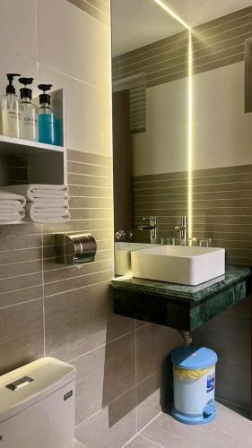 a bathroom with a sink and a mirror and a toilet at ĐÔNG NHƯ HOTEL in Ho Chi Minh City