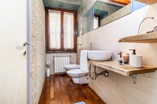 une salle de bain avec un lavabo et des toilettes dans l'établissement Soffio del Lago, à Pusiano