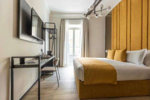 a bedroom with a bed and a desk and a television at Home at Rome Luxury Navona Guesthouse in Rome