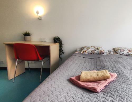 タリンにあるTallinn Airport Stayのベッドルーム1室(デスク、ベッド1台、赤い椅子付)