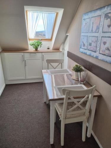 a kitchen with a table and chairs and a window at Ferienwohnung Taube Hildesheim in Hildesheim