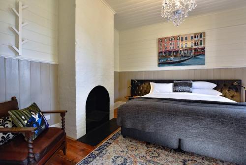 ein Schlafzimmer mit einem Bett und einem Kamin in der Unterkunft Heritage Cottage Daylesford in Daylesford
