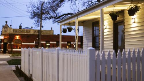 a white picket fence in front of a house at Heritage Cottage Daylesford in Daylesford