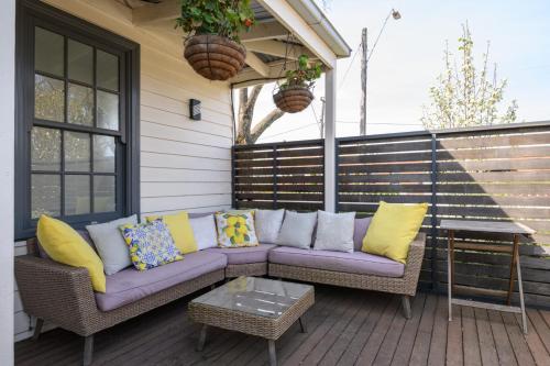eine Terrasse mit einem lila Sofa und einem Tisch in der Unterkunft Heritage Cottage Daylesford in Daylesford