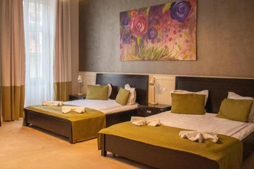 a room with two beds and a painting on the wall at Hirscher Loft in Braşov