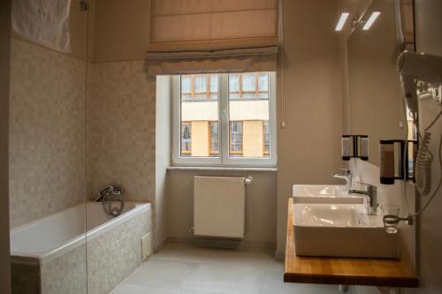 a bathroom with a sink and a tub and a window at Hirscher Loft in Braşov