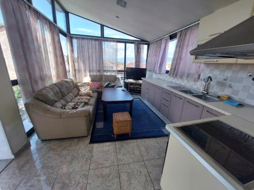 a living room with a couch and a table in a kitchen at D Friendship Apartment in Shkodër