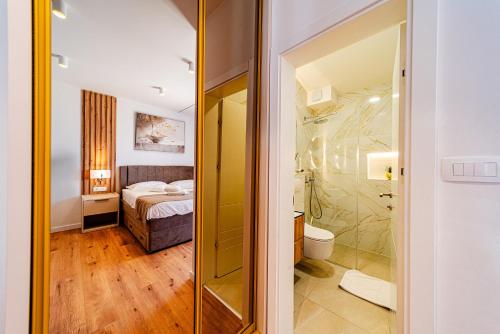 a bathroom with a shower and a bedroom with a bed at Bed & Breakfast Villa Vrgorac in Orebić
