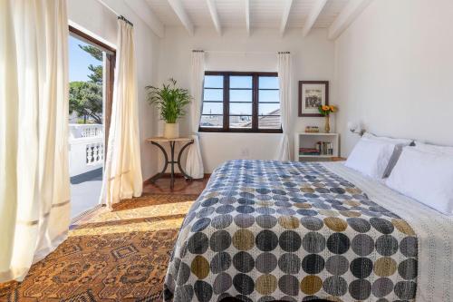 a bedroom with a bed and a large window at Axminster House in Muizenberg