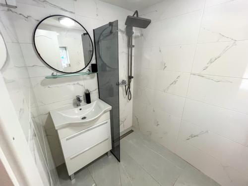 a white bathroom with a sink and a mirror at Robinson Ina 1 in Gdinj