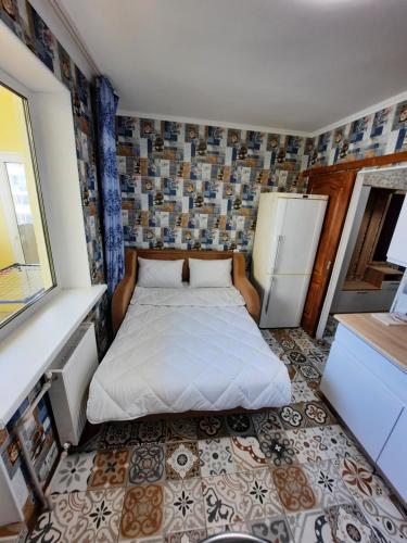 a small bedroom with a bed and a refrigerator at Двокімнатна квартира з кондиционером документи на відрядження in Poltava