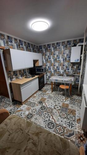 a kitchen with a table and a tile wall at Двокімнатна квартира з кондиционером документи на відрядження in Poltava