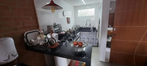 a kitchen with a counter with cups and a sink at CASA DO BRAZ casas de temporada in Monte Verde