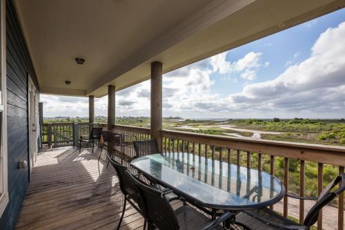 a balcony with a glass table and chairs on it at Sandy Hook in Galveston