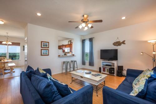 a living room with blue couches and a table at Sandy Hook in Galveston