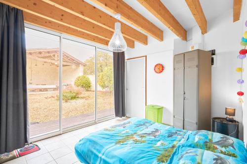 une chambre avec un lit et une grande fenêtre dans l'établissement Loft piscine chauffée et couverte, à Sauvignac