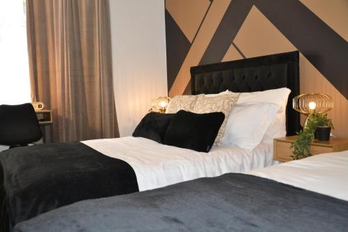 a bedroom with a large bed with white sheets and black pillows at Coventry Studio in Parkside