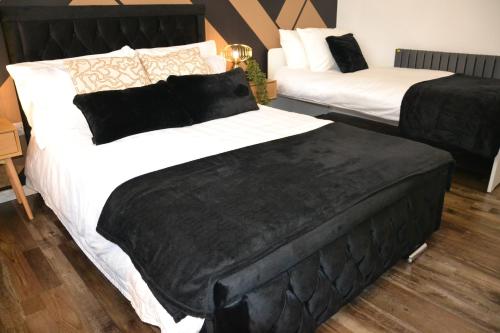 a bedroom with two beds with black and white sheets at Coventry Studio in Parkside