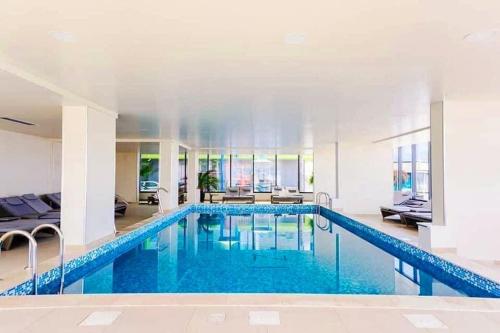 a large pool with blue water in a building at Luxury Seaside Apartment Alezzi Green Swimming Pool in Mamaia Nord