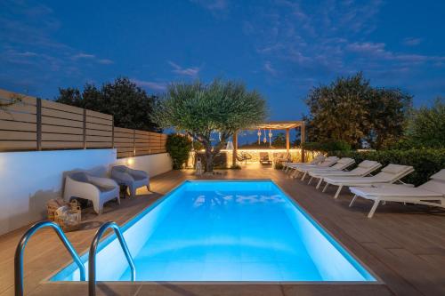 una piscina con tumbonas y una piscina en Terpsis Pool Villa, en Rodas