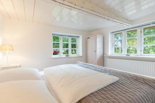 a white bedroom with two beds and two windows at Reethus Humptrup in Humptrup