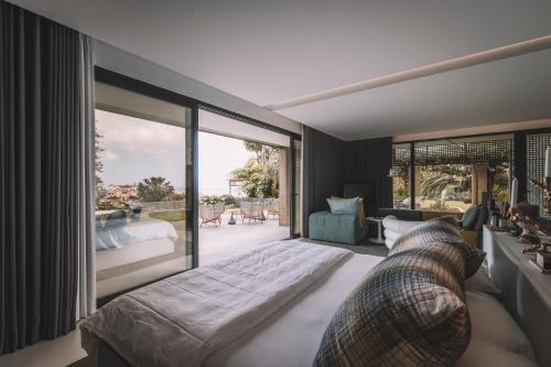 a bedroom with a large bed and a large window at VILLA QUINTA TORRINHA Rooms in Funchal