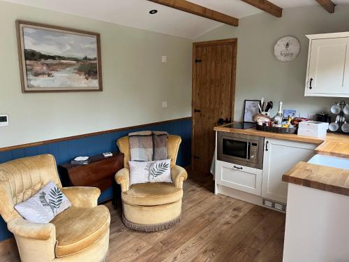 eine Küche mit 2 Stühlen und einer Arbeitsplatte in der Unterkunft Martins Meadow Private Wellness Escape in Ballynahinch